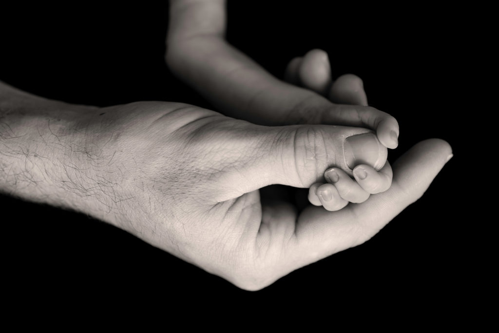 newborn boy and dad hands